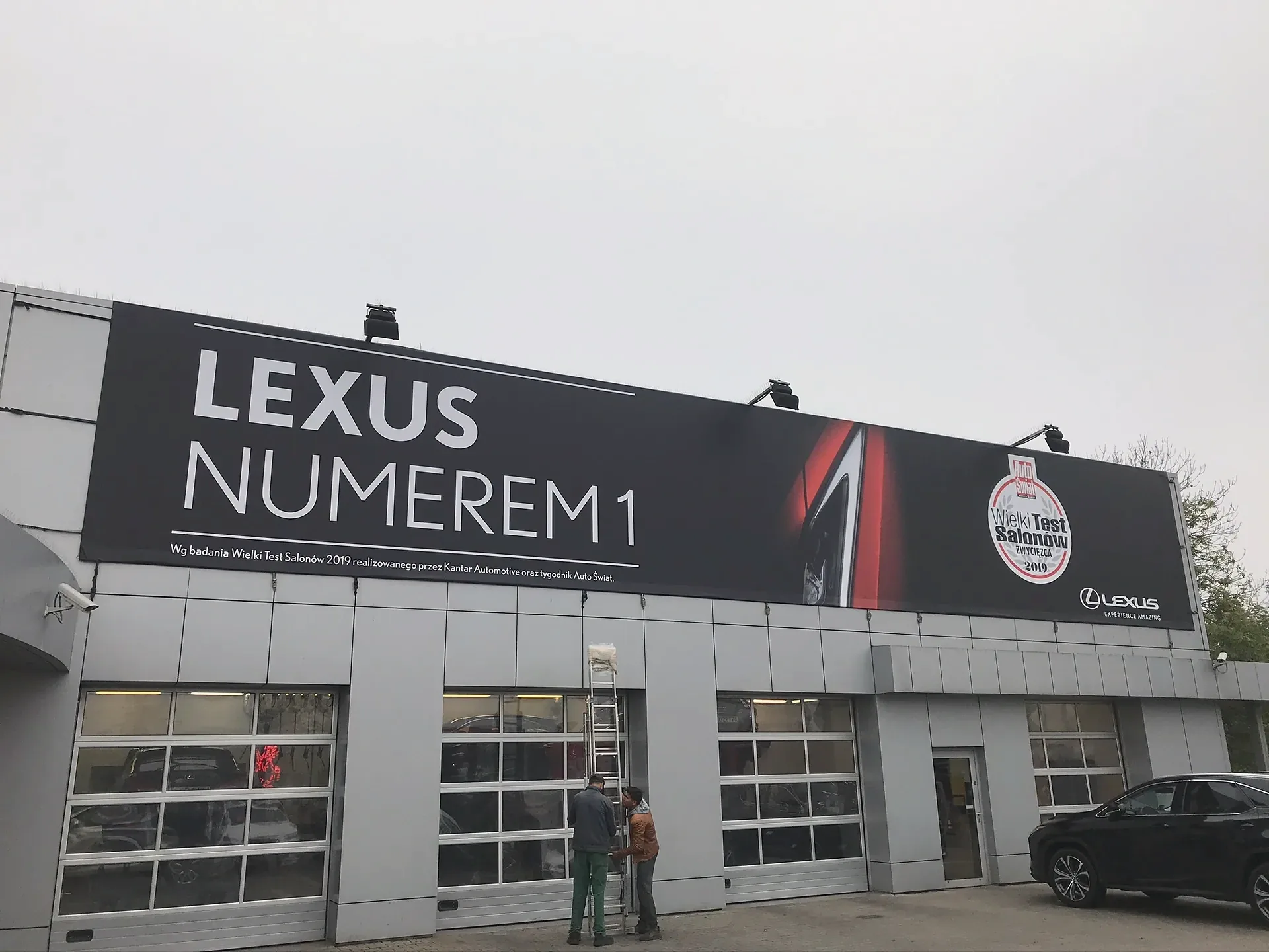 Montaż wielkoformatowego baneru na fasadzie salonu Lexus