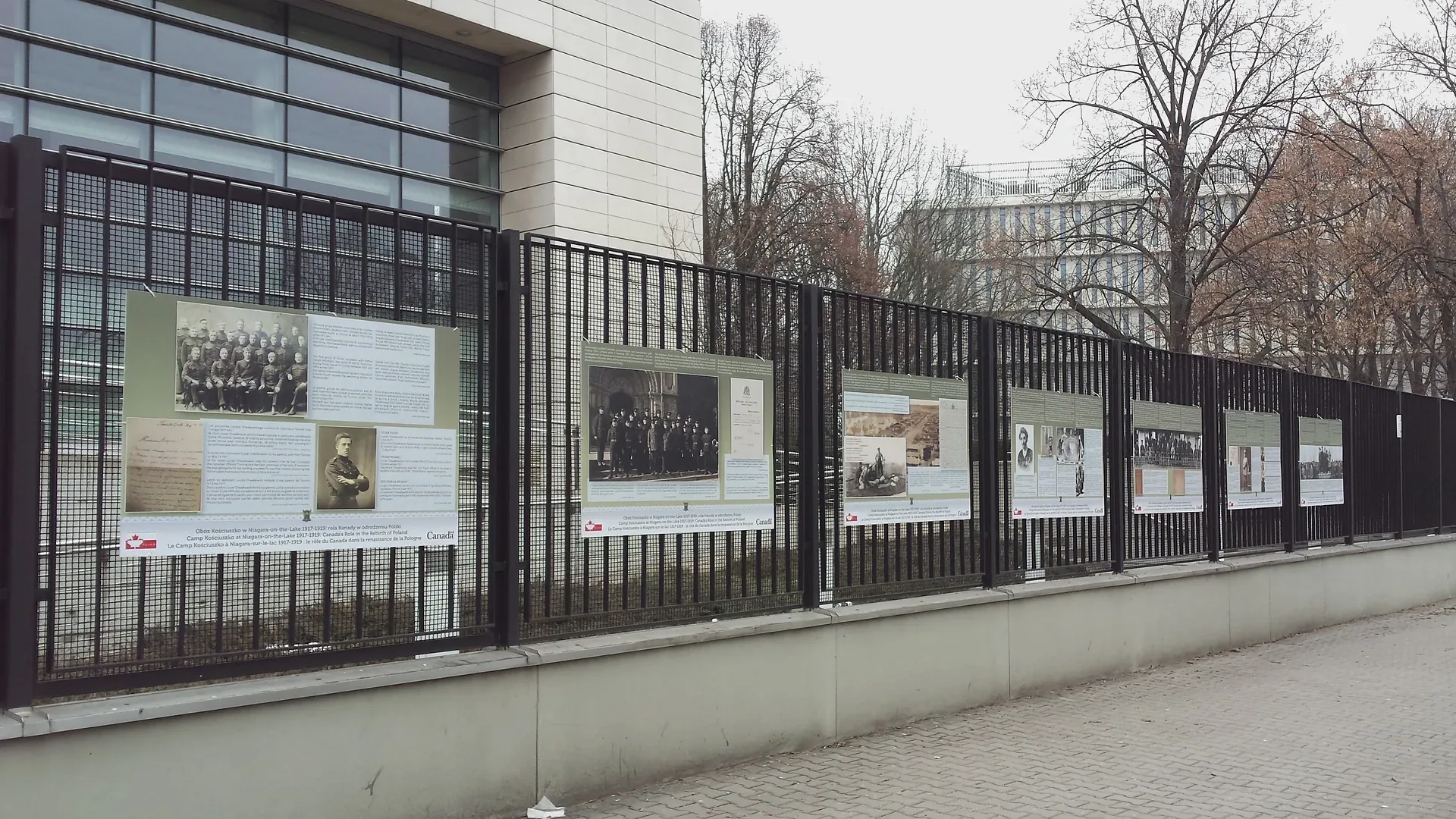 Plansze plenerowej wystawy portretów zamontowane na ogrodzeniu — ujęcie 3